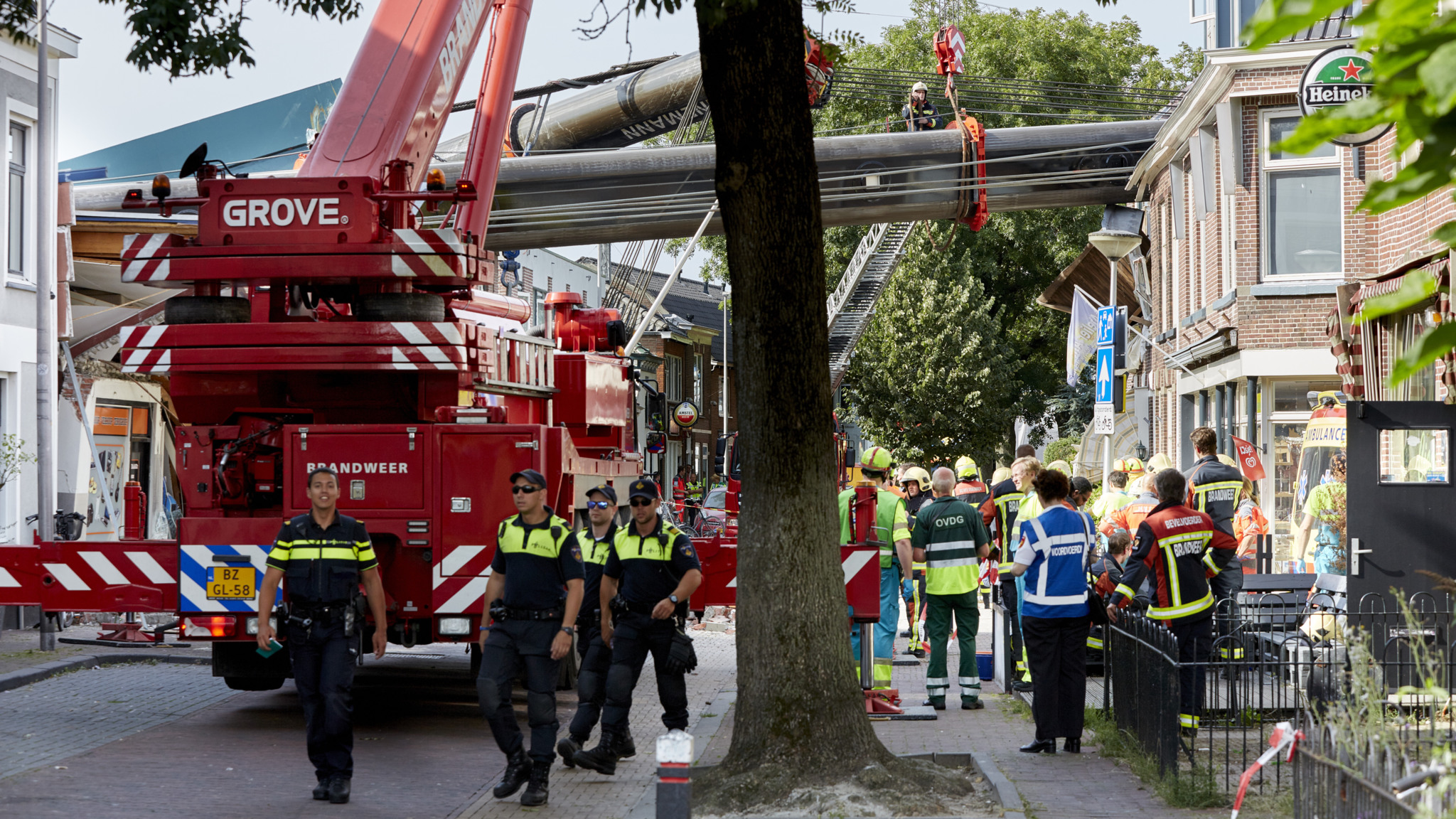 Kranen met brugdeel vallen op huizen