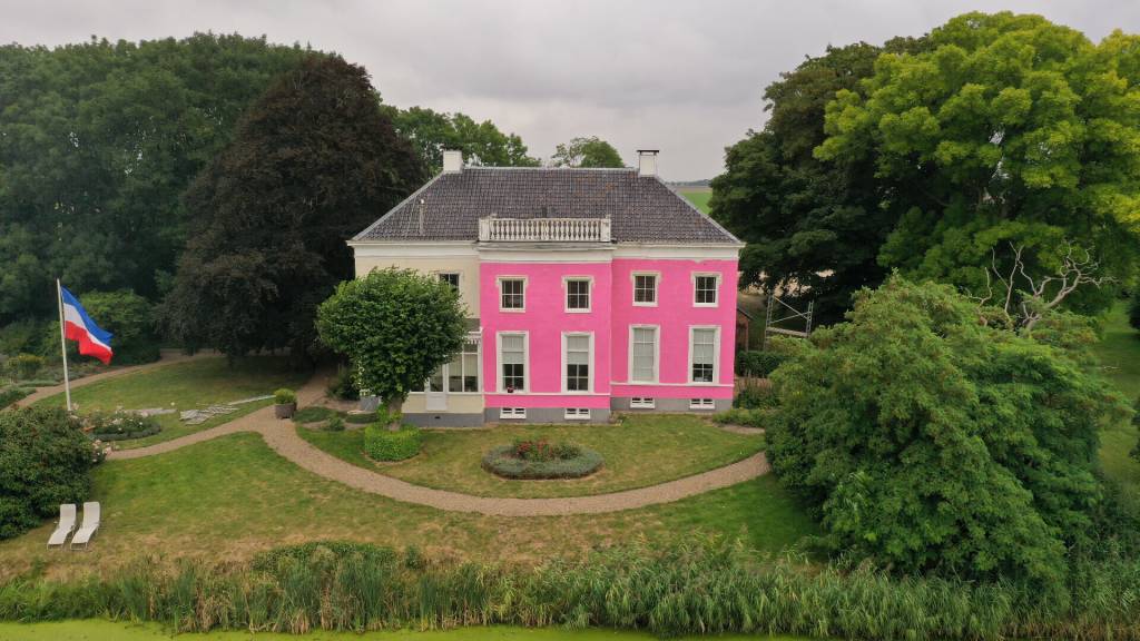 Mensen schilderen oude boerderij roze uit protest