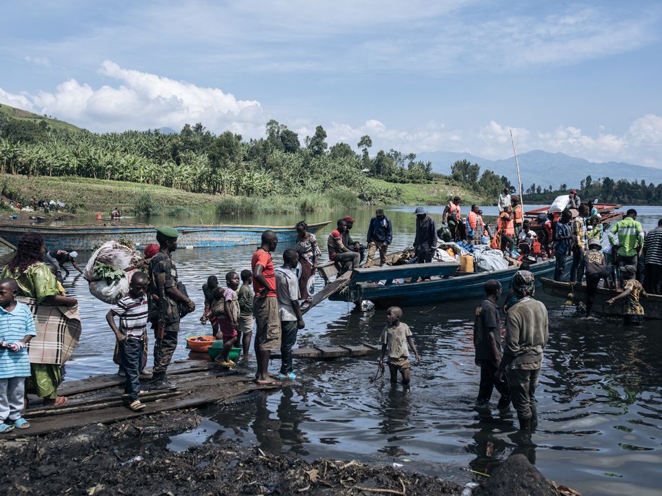 Passengers wait ⁢at a snow-covered airport terminal.