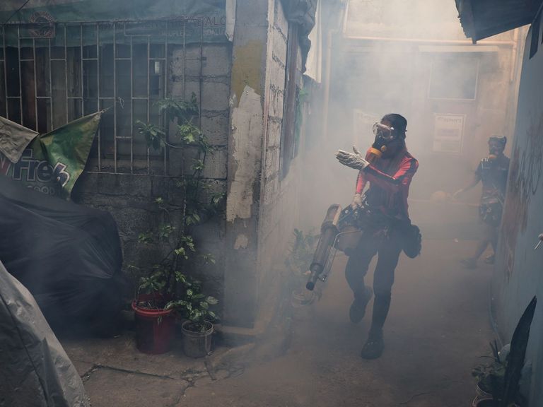 Emergency aid teams conduct spraying campaigns against dengue mosquitoes in Manila, where lack of public awareness led to water stagnation increasing dengue spreadhood and infections.