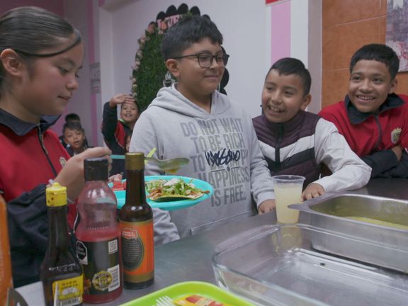 Mexican children eat in class