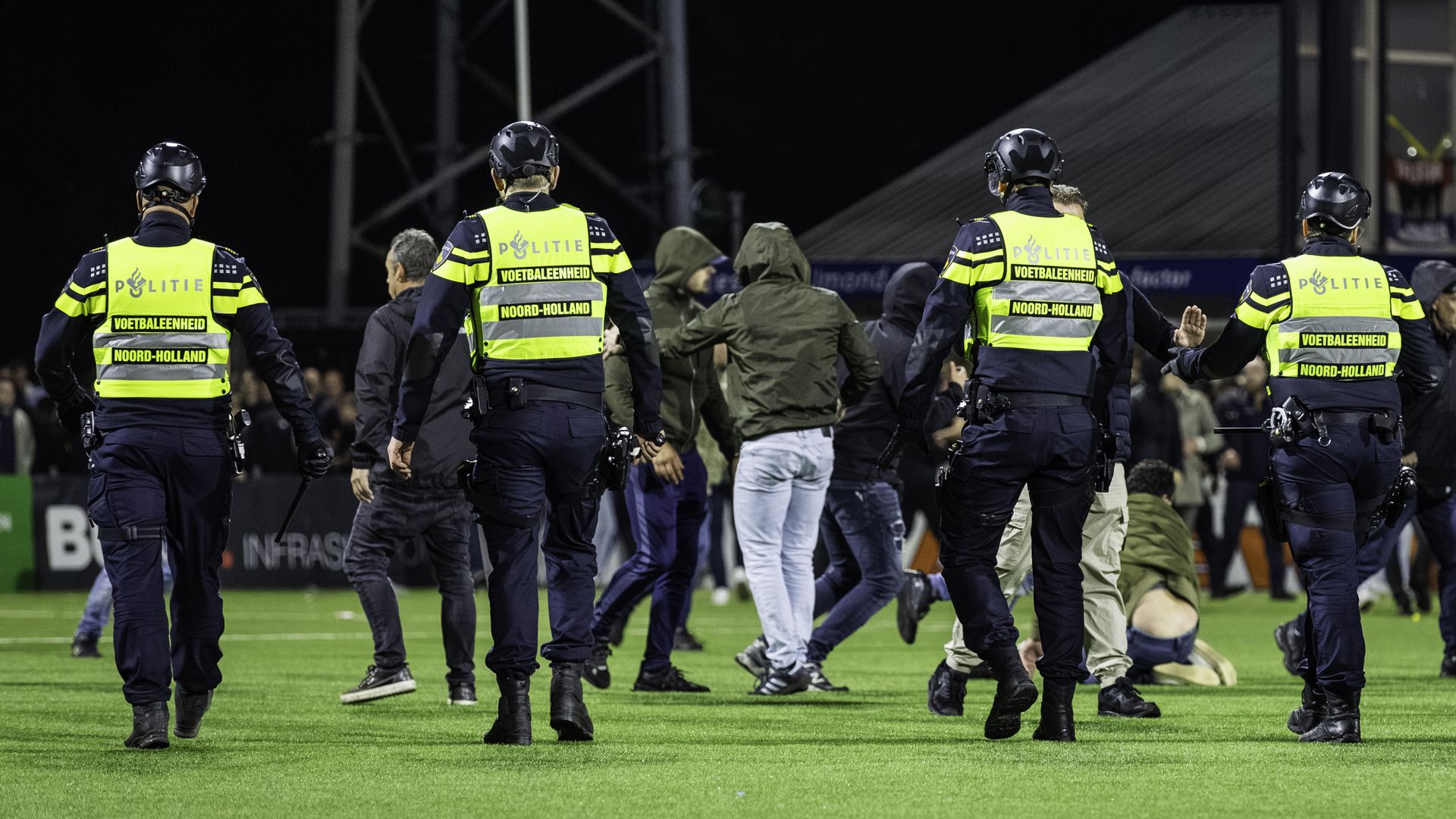 Police confronting rioters on a soccer field