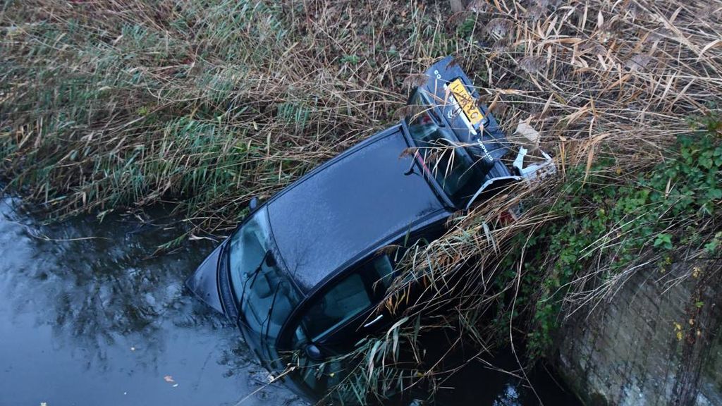 Foto: Auto belandt in sloot in Zeeland, man aangehouden op verdenking van mishandeling
