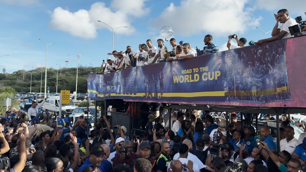 Curaçaose voetbalploeg in open bus door Willemstad na behalen WK-ticket