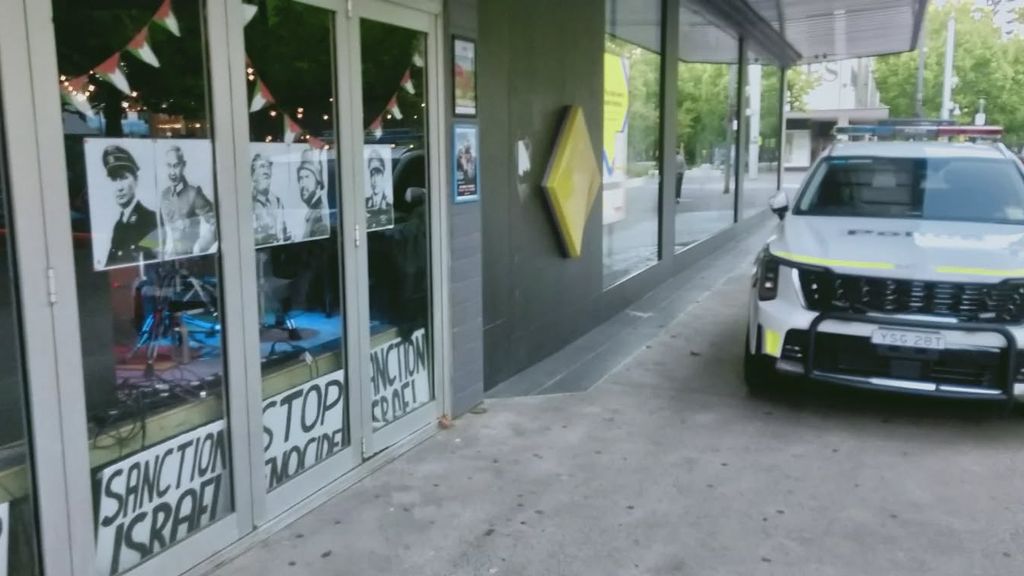 Foto: Australische politie verwijdert posters van Poetin en Trump in nazi-uniform uit bar 